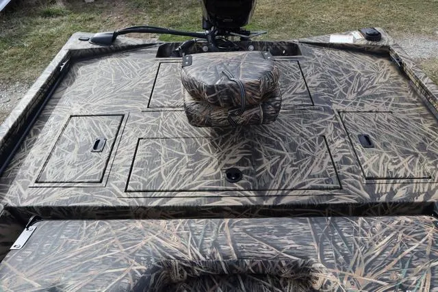 Slide: The Image of 2024 Lowe Stinger 175 Poly Camo boat with camouflage design, featuring storage compartments. - 6