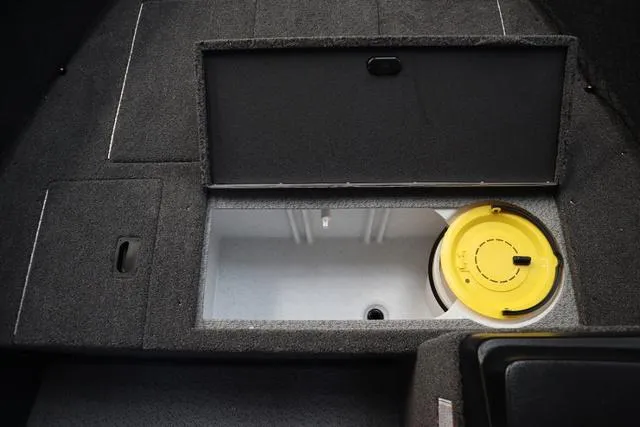 Slide: The Image of 2025 Crestliner 1650 Kodiak SC boat storage compartment with open lid and yellow container. - 4