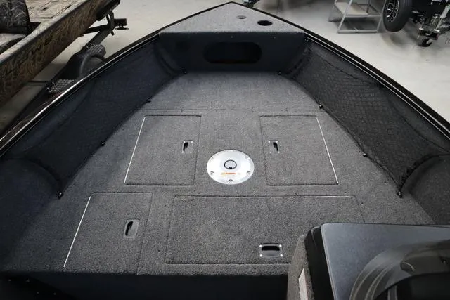 Slide: The Image of 2025 Crestliner 1650 Kodiak SC boat interior with carpeted deck and storage compartments. - 7