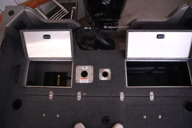 Slide: The Image of 2025 Lowe FM 1775 WT boat interior with open storage compartments and motor. - 10