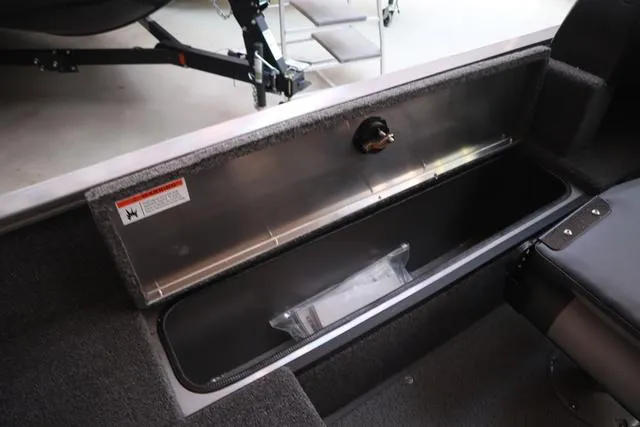 Slide: The Image of 2025 Lowe FM 1775 WT boat storage compartment with open lid and visible interior. - 11