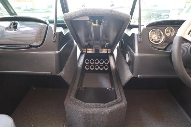 Slide: The Image of 2025 Lowe FM 1775 WT boat interior with open storage compartment and dashboard controls. - 14