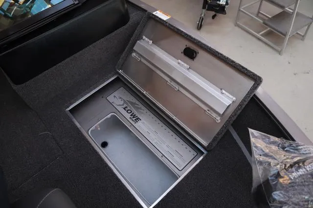 Slide: The Image of 2025 Lowe FM 1775 WT boat storage compartment with open lid, showcasing interior design. - 16