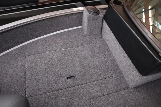 Slide: The Image of Interior of 2025 Lowe FM 1775 WT boat, featuring carpeted flooring and storage compartment. - 17