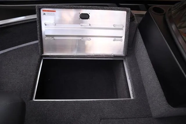 Slide: The Image of Open storage compartment in 2025 Lowe FM 1775 WT boat, featuring carpeted interior. - 18