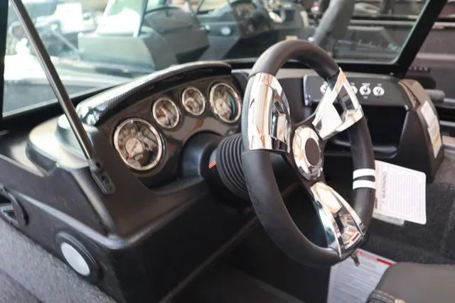 Slide: The Image of 2025 Lowe FM 1775 WT boat dashboard with steering wheel and gauges. - 5