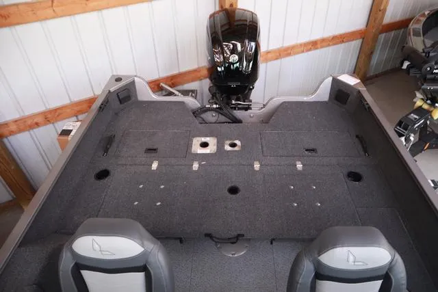 Slide: The Image of 2025 Lowe FM 1775 WT boat interior with spacious deck and motor in a storage shed. - 9