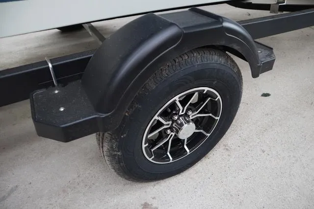Slide: The Image of 2025 Lowe FM 1775 WT trailer wheel with black fender on concrete surface. - 6