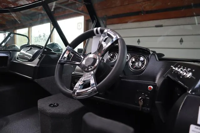 Slide: The Image of Interior of 2025 Lowe FM 1775 WT boat, featuring sleek steering wheel and dashboard controls. - 7