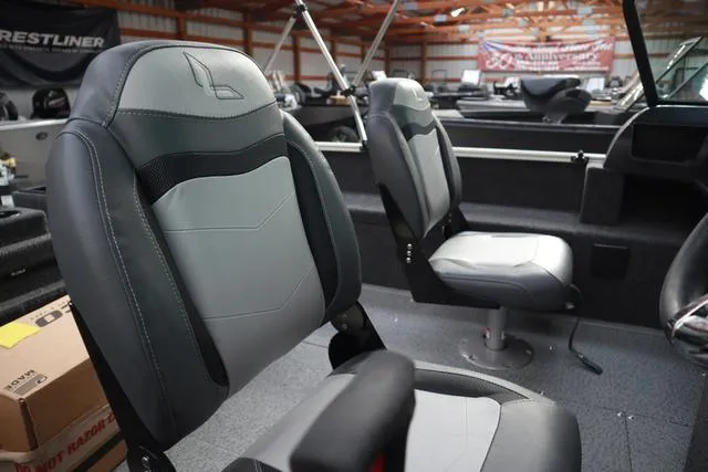 Slide: The Image of 2025 Lowe FM 1775 WT boat interior with gray and black seating in a showroom. - 8