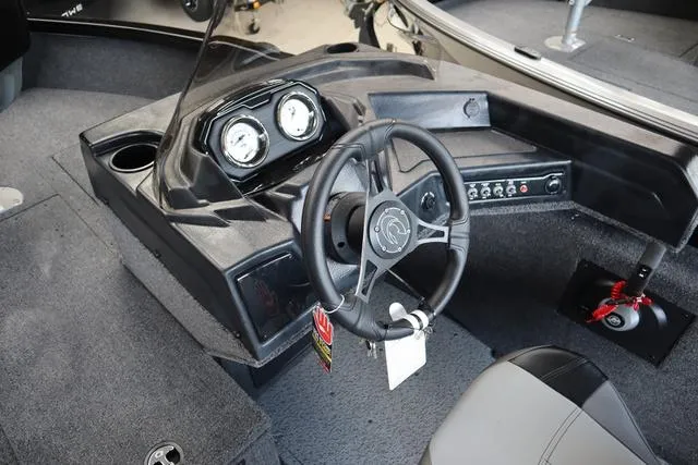 Slide: The Image of 2024 Crestliner 1650 Fish Hawk JS SC boat interior with steering wheel and dashboard controls. - 3