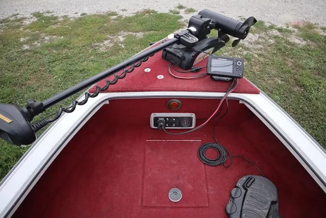Slide: The Image of 1997 Princecraft 178 boat interior with trolling motor and fish finder on red carpet. - 6