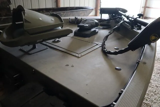 Slide: The Image of 2020 Tracker 1448AW Grizzly boat deck with mounted equipment in a storage area. - 4