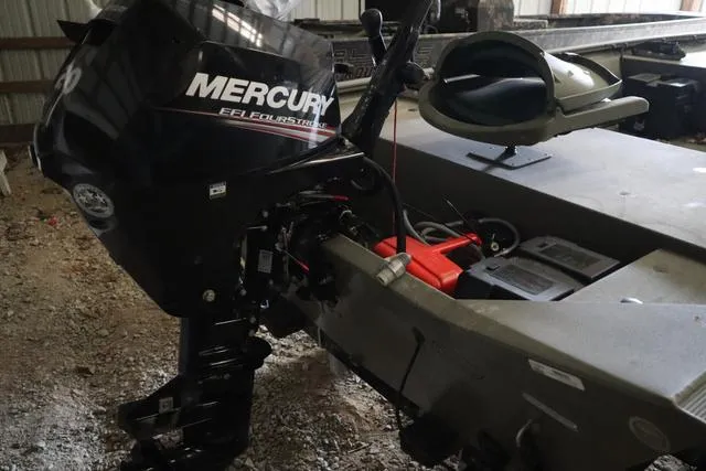 Slide: The Image of 2020 Tracker 1448AW Grizzly boat with Mercury outboard motor in a storage area. - 5