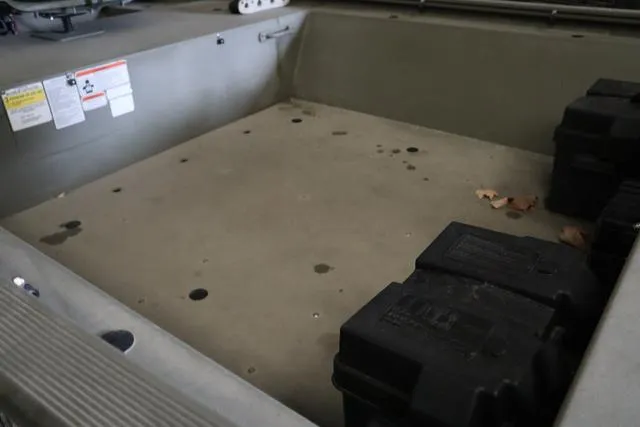 Slide: The Image of 2020 Tracker 1448AW Grizzly boat interior with storage compartments and safety labels. - 6