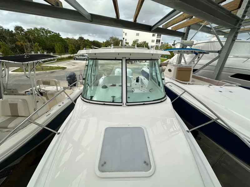 Slide: The Image of 2008 Pro-Line 26 XP boat docked in a marina, surrounded by other vessels. - 28