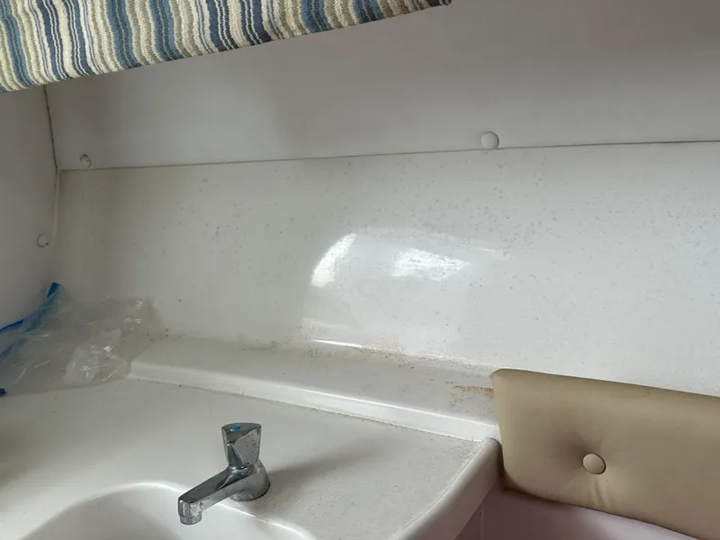 Slide: The Image of 2008 Pro-Line 26 XP boat interior with sink and striped curtain. - 34