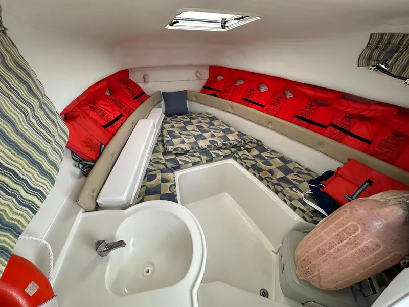 Slide: The Image of 2008 Pro-Line 26 XP boat cabin with life jackets, patterned cushions, and a small sink. - 7