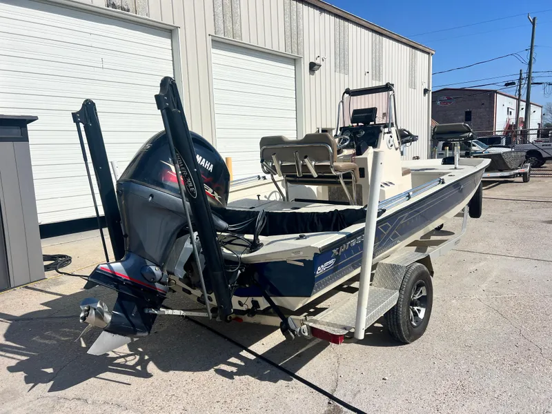 Slide: The Image of 2019 Xpress H20B boat with Yamaha outboard motor on trailer, parked outside a building. - 8