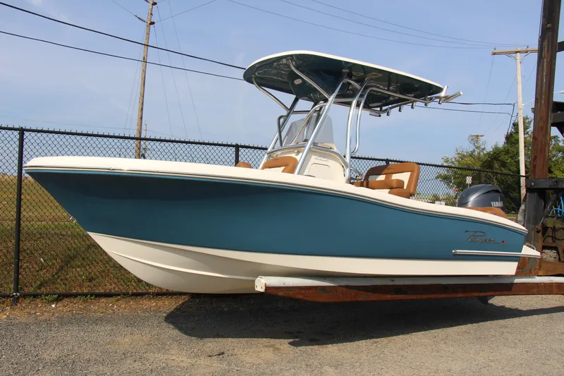 Slide: The Image of 2025 Pioneer 202 Islander boat with blue hull and T-top on trailer. - 0