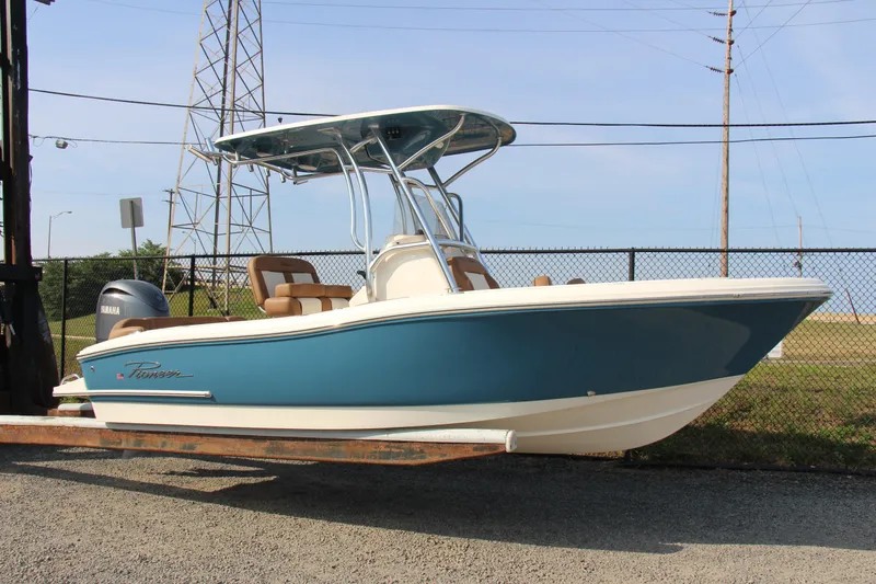 Slide: The Image of 2025 Pioneer 202 Islander boat with Yamaha engine, blue hull, parked outdoors. - 10
