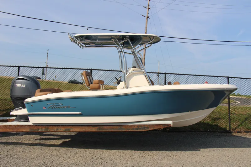 Slide: The Image of 2025 Pioneer 202 Islander boat with Yamaha engine, blue and white design, parked outdoors. - 12