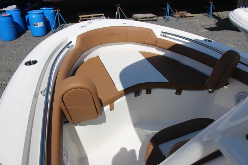 Slide: The Image of 2025 Pioneer 202 Islander boat interior with brown and white seating, docked outdoors. - 6