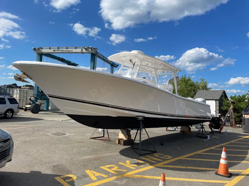 Slide: The Image of 2023 Southport 33 FE boat on display in a marina parking area. - 3