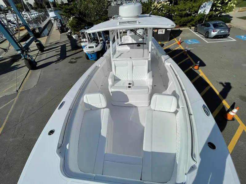 Slide: The Image of 2023 Southport 33 FE boat with spacious seating and sleek design at a marina. - 5