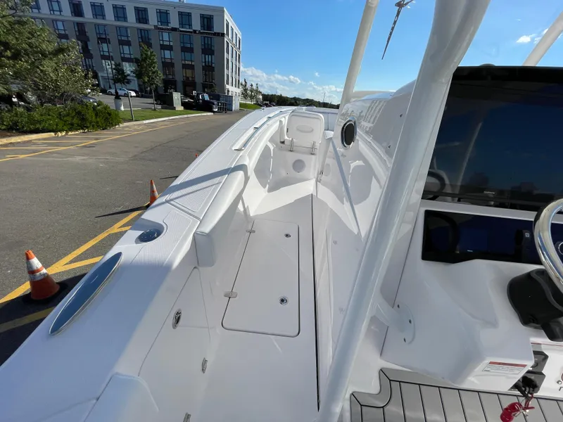 Slide: The Image of 2023 Southport 33 FE boat docked near a modern building under a clear blue sky. - 7
