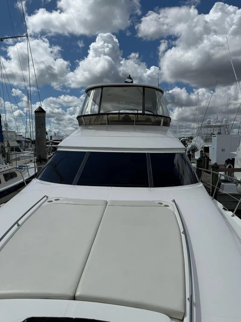 Slide: The Image of 2000 Sea Ray 560 Sedan Bridge yacht under cloudy sky at marina. - 7