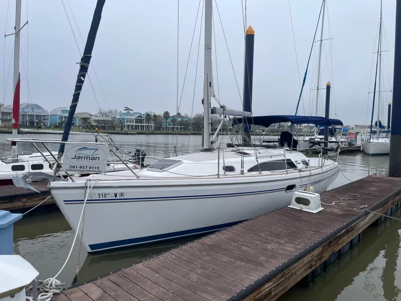 Slide: The Image of 2008 Catalina 309 sailboat docked at a marina, overcast sky, calm waters. - 0