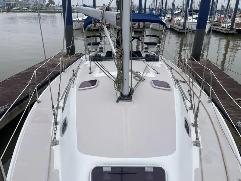 Slide: The Image of 2008 Catalina 309 sailboat docked at marina, showcasing deck and mast. - 13