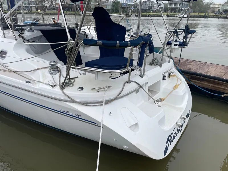 Slide: The Image of 2008 Catalina 309 sailboat docked by the water, featuring a sleek white design. - 14