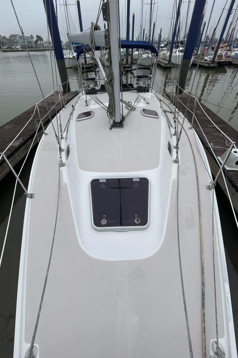 Slide: The Image of 2008 Catalina 309 sailboat docked, showcasing deck and rigging. - 17