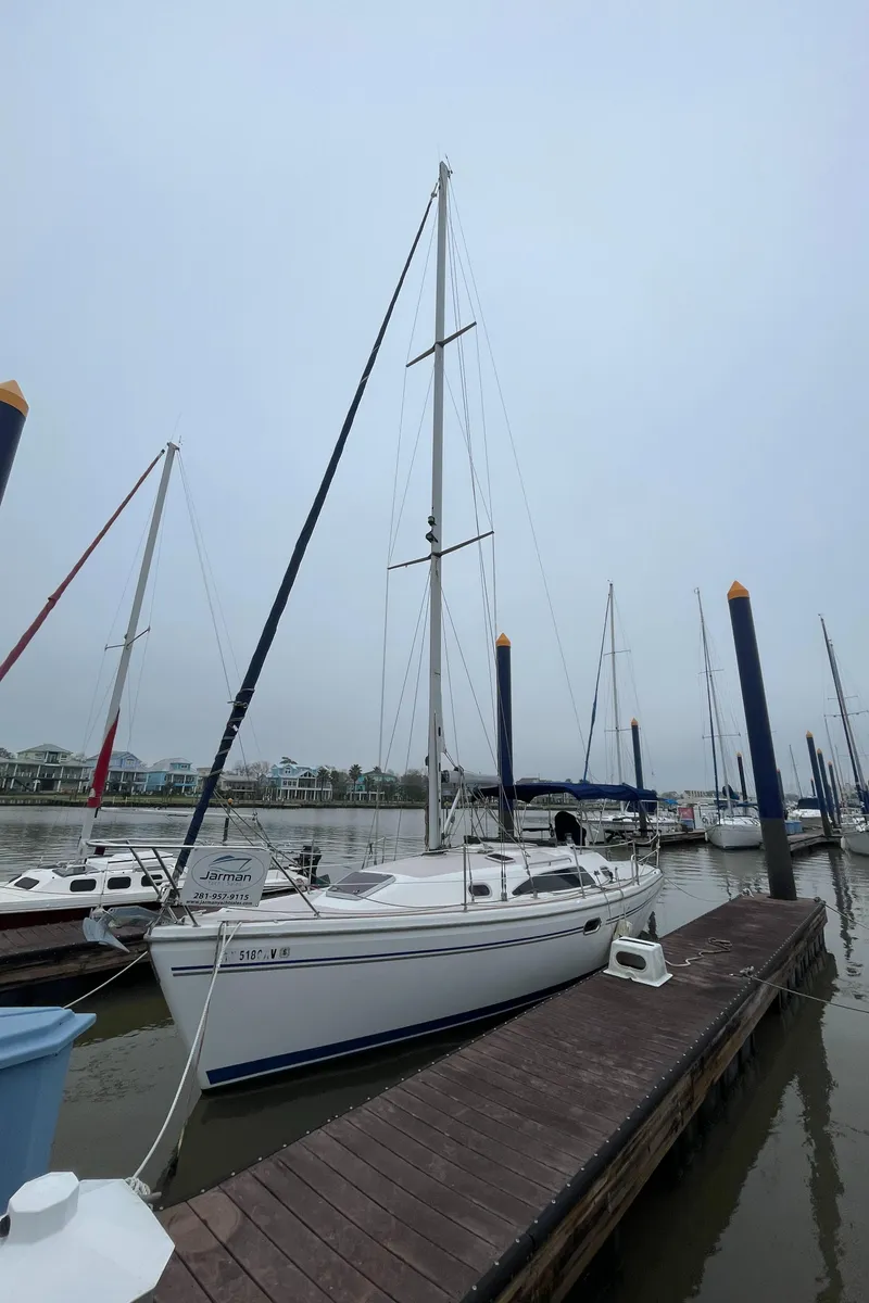 Slide: The Image of 2008 Catalina 309 sailboat docked at a marina on a cloudy day. - 2