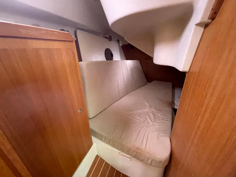 Slide: The Image of Interior cabin of 2008 Catalina 309 sailboat with cushioned seating and wooden paneling. - 23