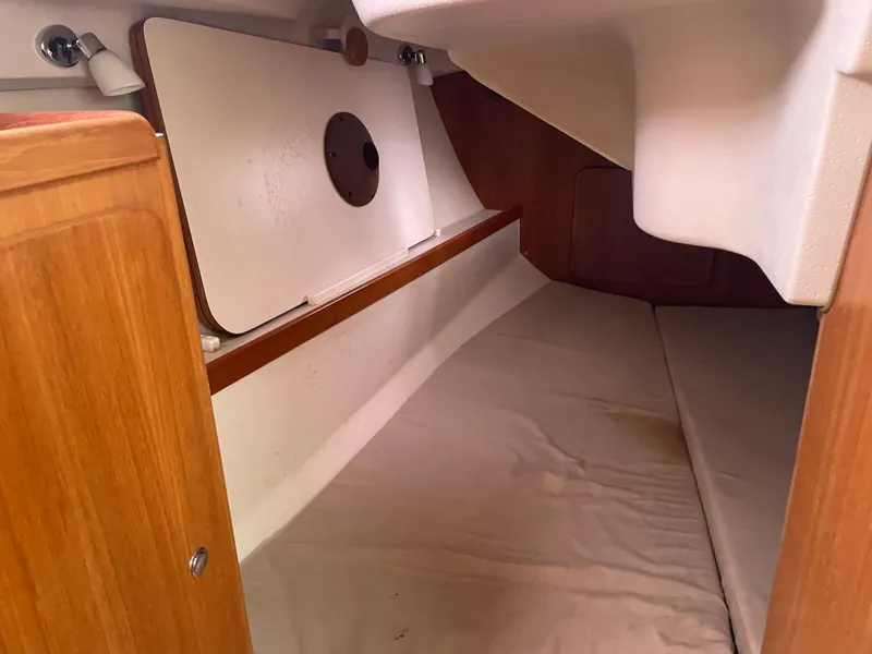 Slide: The Image of Interior cabin of a 2008 Catalina 309 sailboat, featuring wooden finishes and storage space. - 25
