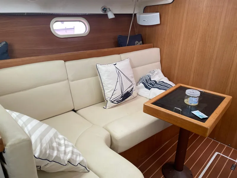 Slide: The Image of Interior of 2008 Catalina 309 sailboat with cozy seating and nautical-themed pillows. - 26