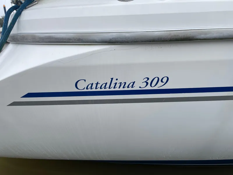 Slide: The Image of 2008 Catalina 309 sailboat hull with blue and gray stripes. - 6