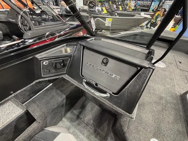 Slide: The Image of 2025 Crestliner 1850 Fish Hawk WT JS boat interior with storage compartment and control panel. - 12
