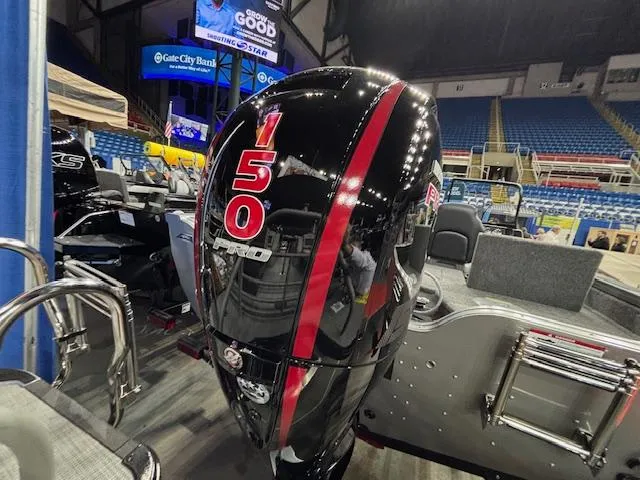 Slide: The Image of 2025 Crestliner 1850 Fish Hawk WT JS with powerful 150 HP engine at indoor boat show. - 3