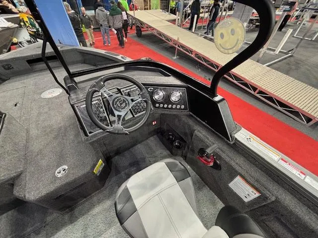 Slide: The Image of 2025 Crestliner 1850 Fish Hawk WT JS boat interior with steering wheel and dashboard controls. - 7