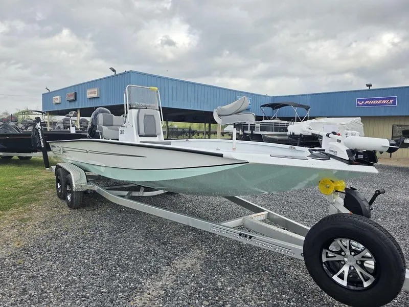 Slide: The Image of 2025 Xpress H22B boat on trailer, parked outside dealership under cloudy sky. - 31