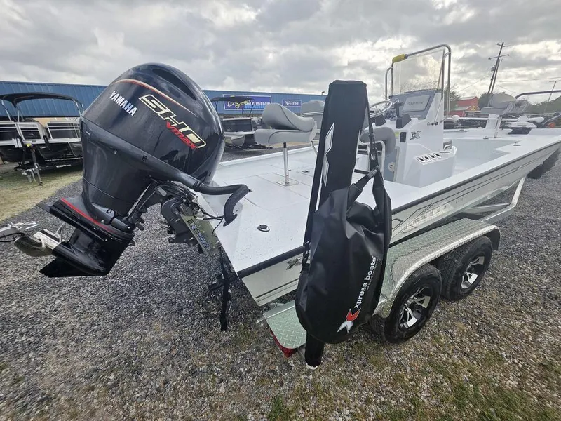 Slide: The Image of 2025 Xpress H22B boat with Yamaha outboard motor on a trailer, parked on gravel. - 8