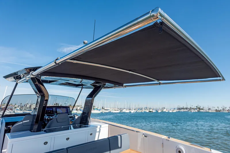 Slide: The Image of 2023 Pardo Yachts P38 with sunshade, docked in a marina under clear blue skies. - 19