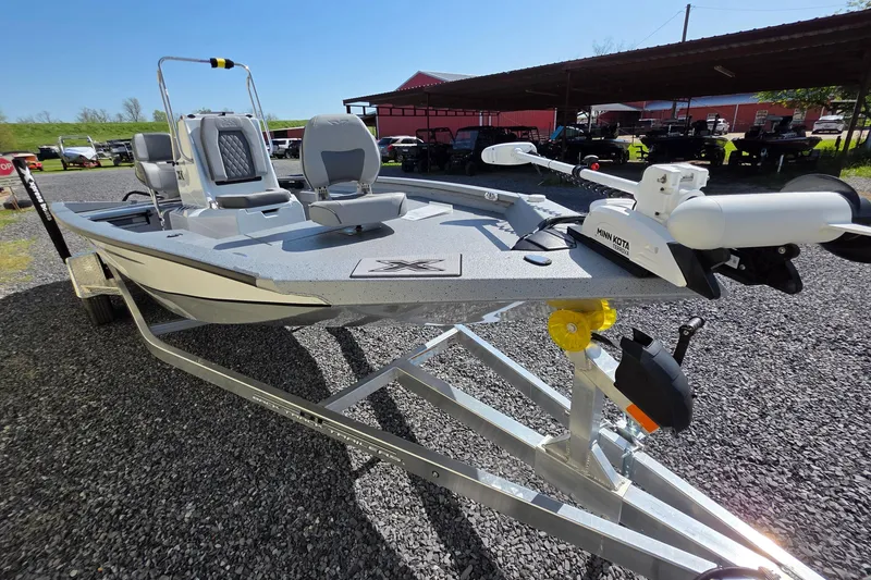 Slide: The Image of 2025 Xpress H20B Bay boat on trailer, featuring Minn Kota trolling motor. - 11