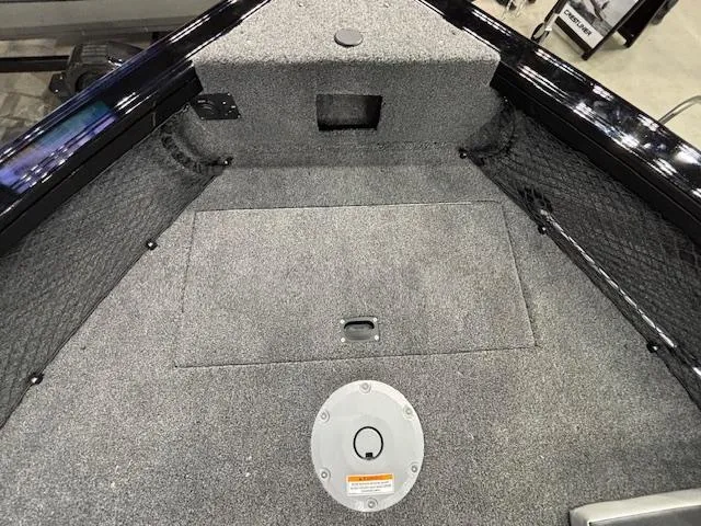 Slide: The Image of Interior view of 2025 Crestliner 1850 Super Hawk WT JS boat, featuring carpeted storage area. - 14