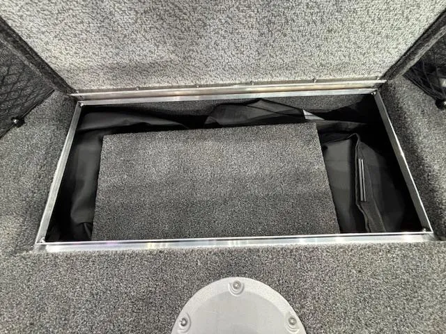 Slide: The Image of Storage compartment of 2025 Crestliner 1850 Super Hawk WT JS boat, featuring carpeted interior. - 15