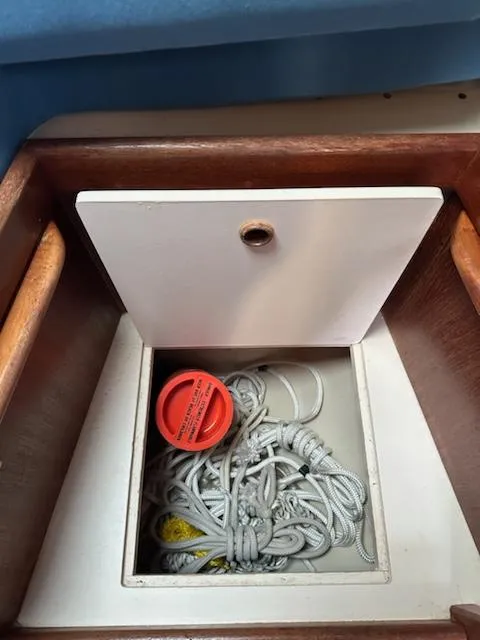 Slide: The Image of Storage compartment on 1985 Ericson 30 Plus boat with ropes and a red cap. - 12